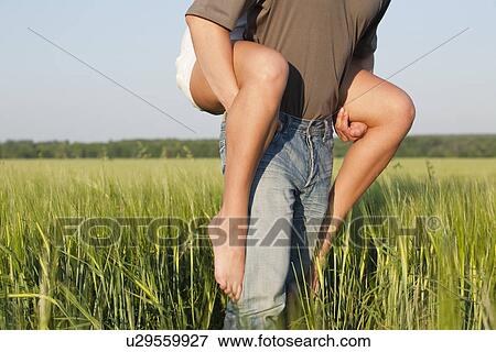 Stock Photo - Russia, Voronezh, man giving woman piggy back ride. Fotosearch