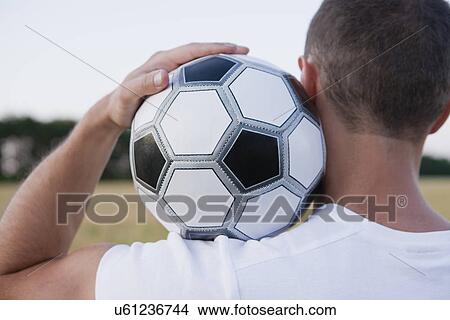 Picture - Russia, Voronezh, man holding soccer ball. Fotosearch