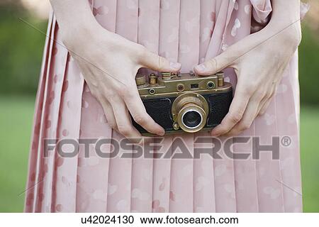 Stock Image - Russia, Voronezh, midsection of woman holding old camera. Fotosearch