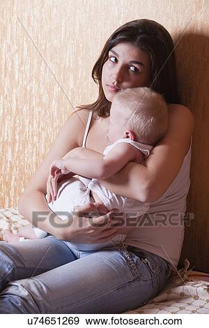 Russia, Voronezh, mother with son (12-17 months) sitting on bed View Large Photo Image Stock Photo - Russia, Voronezh, mother with son (12-17 months) sitting on bed. Fotosearch