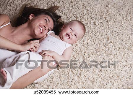 Russia, Voronezh, mother with son (12-17 months) lying on floor View Large Photo Image Stock Photography - Russia, Voronezh, mother with son (12-17 months) lying on floor. Fotosearch