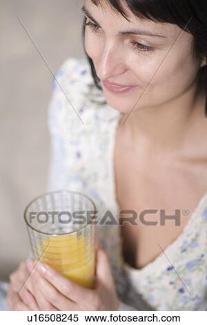 Stock Photography - Russia, Voronezh, woman holding glass of orange juice. Fotosearch