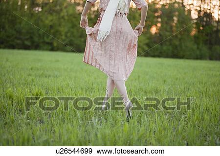 Stock Photo - Russia, Voronezh, woman in dress running across meadow. Fotosearch