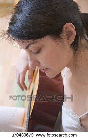 Stock Image - Russia, Voronezh, Woman playing guitar. Fotosearch