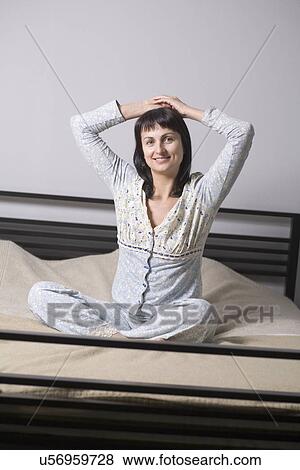 Stock Photo - Russia, Voronezh, woman stretching on bed. Fotosearch