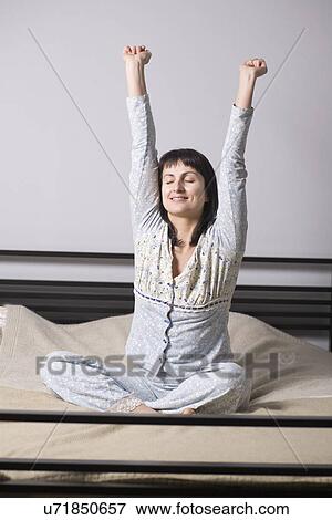 Stock Photo - Russia, Voronezh, woman stretching on bed. Fotosearch