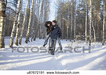 Russia, Voronezh, Young man giving piggy back ride to girlfriend in snowy park View Large Photo Image Stock Image - Russia, Voronezh, Young man giving piggy back ride to girlfriend in snowy park. Fotosearch