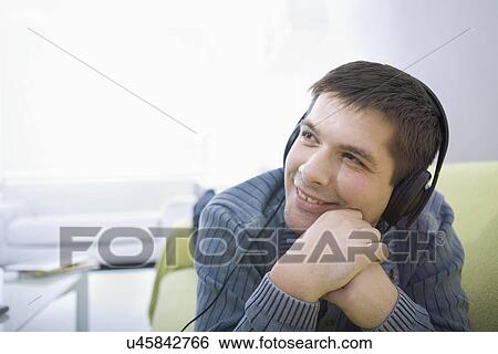 Russia, Voronezh, Young man lying on bed and listening music View Large Photo Image Stock Photograph - Russia, Voronezh, Young man lying on bed and listening music. Fotosearch