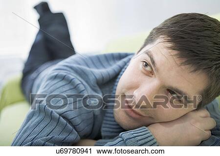 Russia, Voronezh, Young man resting on bed View Large Photo Image Stock Image - Russia, Voronezh, Young man resting on bed. Fotosearch