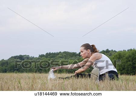 Russia, Voronezh, young woman exercising in field View Large Photo Image Stock Photo - Russia, Voronezh, young woman exercising in field. Fotosearch