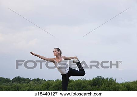 Stock Photo - Russia, Voronezh, young woman exercising in field. Fotosearch