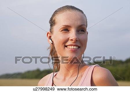 Stock Photo - Russia, Voronezh, young woman wearing earphones. Fotosearch