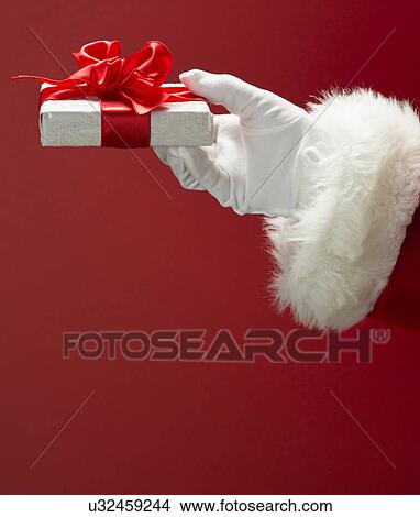 Picture - Santa Claus holding gift. Fotosearch