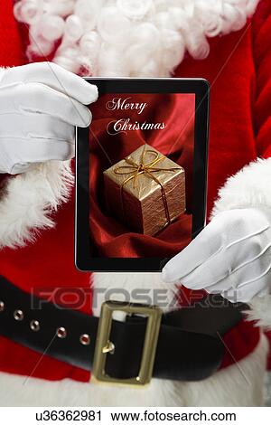 Santa Claus holding tablet with image of gift View Large Photo Image Stock Image - Santa Claus holding tablet with image of gift. Fotosearch