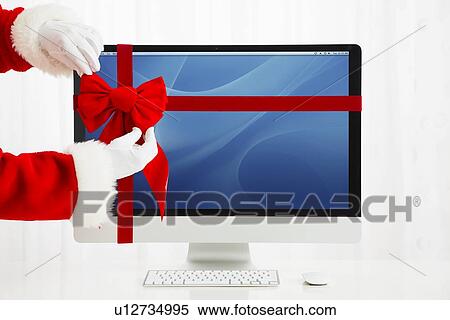 Santa Claus tying bow on computer View Large Photo Image Stock Photography - Santa Claus tying bow on computer. Fotosearch