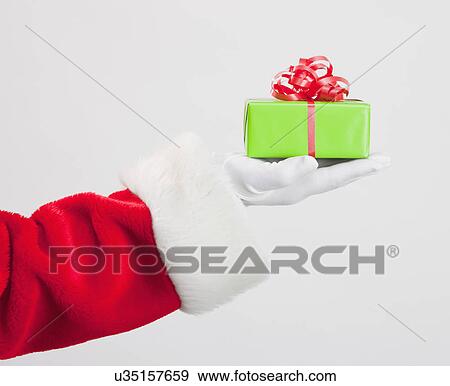 Santa clause holding Christmas gift View Large Photo Image Stock Photo - Santa clause holding Christmas gift. Fotosearch