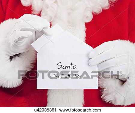 Stock Image - Santa clause holding Christmas letter. Fotosearch