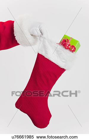 Santa clause holding Christmas stocking with gift View Large Photo Image Stock Photography - Santa clause holding Christmas stocking with gift. Fotosearch