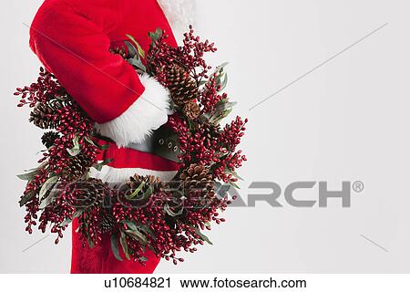 Stock Image - Santa clause holding Christmas wreath. Fotosearch