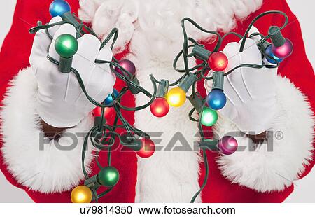Santa clause holding fairy lights View Large Photo Image Stock Image - Santa clause holding fairy lights. Fotosearch