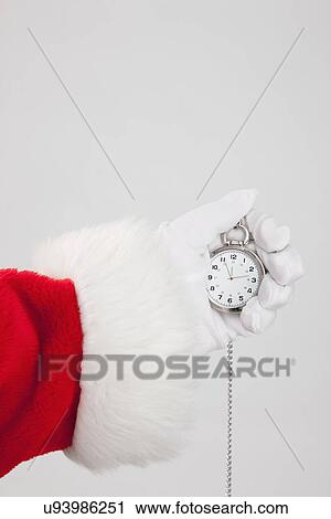 Stock Image - Santa clause holding pocket watch. Fotosearch