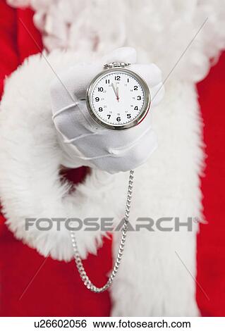 Stock Photograph - Santa clause holding pocket watch. Fotosearch