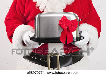 Picture - Santa clause holding toaster Christmas gift. Fotosearch