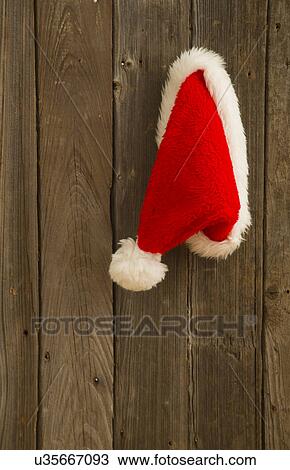 Santa hat hanging on wooden door View Large Photo Image Stock Image - Santa hat hanging on wooden door. Fotosearch