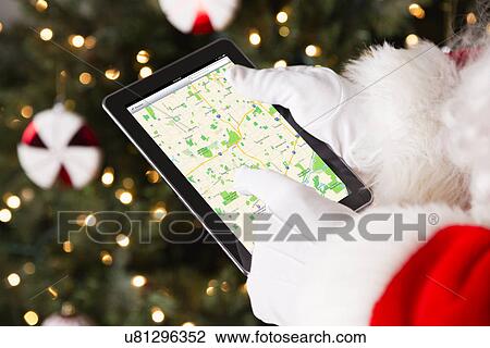 Santa holding digital tablet checking directions View Large Photo Image Stock Image - Santa holding digital tablet checking directions. Fotosearch