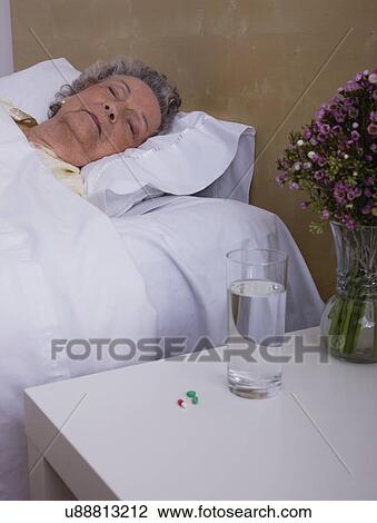 Stock Image - Senior woman asleep in bed. Fotosearch