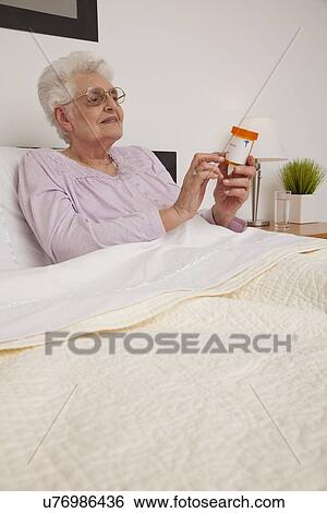 Stock Photograph - Senior woman checking her prescription. Fotosearch