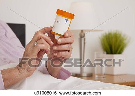 Stock Photograph - Senior woman checking her prescription, close-up. Fotosearch