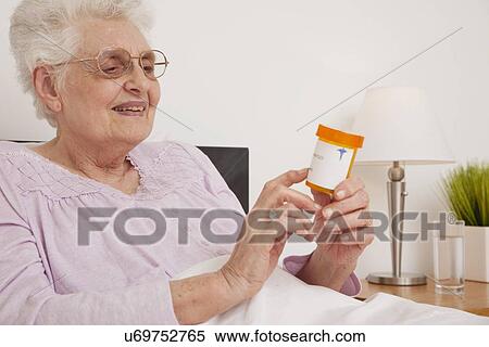 Senior woman checking her prescription View Large Photo Image Stock Photography - Senior woman checking her prescription. Fotosearch