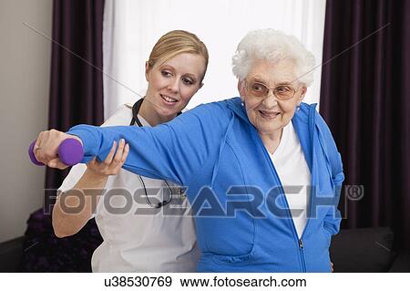 Senior woman exercising with nurse View Large Photo Image Stock Photo - Senior woman exercising with nurse. Fotosearch