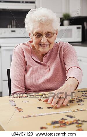 Senior woman playing puzzle View Large Photo Image Stock Photo - Senior woman playing puzzle. Fotosearch