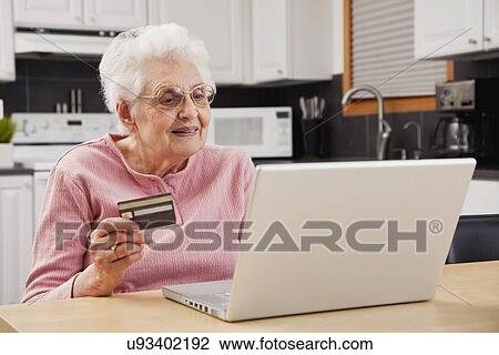 Stock Image - Senior woman shopping online. Fotosearch