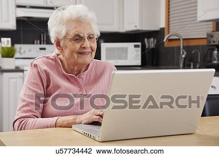 Stock Image - Senior woman using laptop. Fotosearch