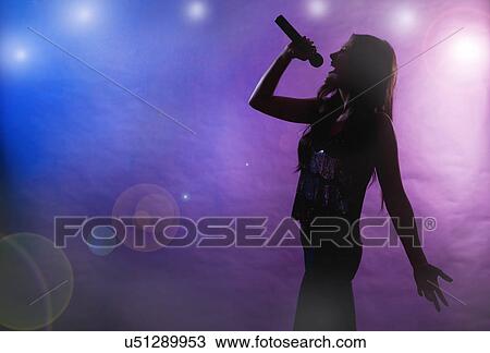 Stock Image - Silhouette of female singer on stage. Fotosearch
