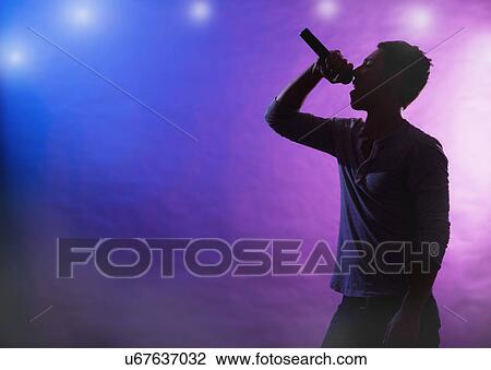 Stock Image - Silhouette of male singer on stage. Fotosearch