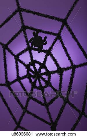 Stock Image - Silhouette of spider on purple background. Fotosearch