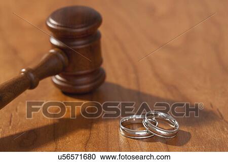 Stock Image - Silver wedding rings and gavel. Fotosearch