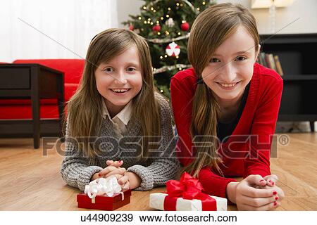 Sisters (8-9, 10-11) posing with Christmas gifts View Large Photo Image Stock Photo - Sisters (8-9, 10-11) posing with Christmas gifts. Fotosearch