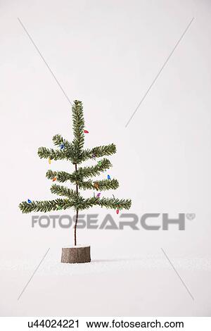 Stock Image - Small Christmas tree against white background. Fotosearch