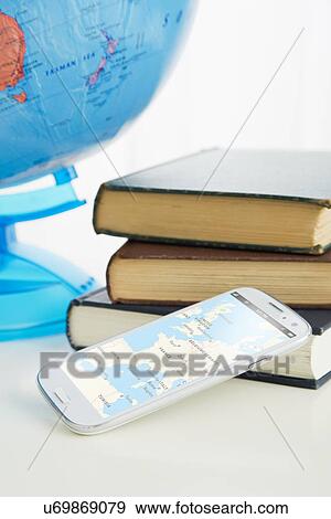 Stock Photo - Smartphone and stack of books. Fotosearch