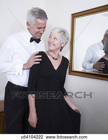 Stock Image - Smiling mature couple in evening wear. Fotosearch