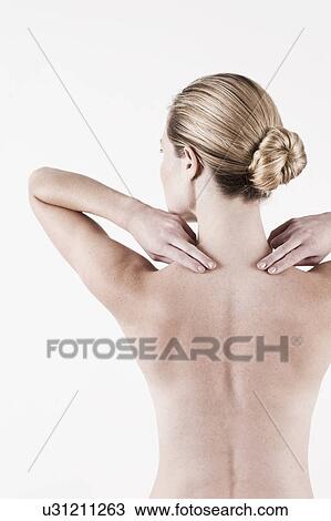 Stock Image - South Africa, Cape Town, Rear view of shirtless young woman touching neck. Fotosearch