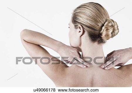 Stock Photo - South Africa, Cape Town, Rear view of shirtless young woman touching neck. Fotosearch