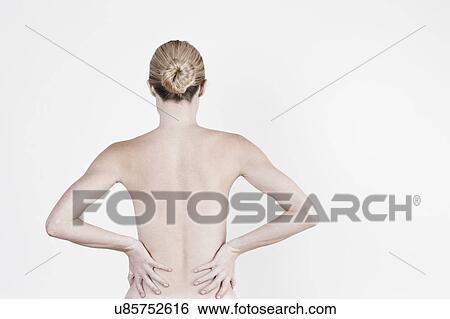 Stock Photograph - South Africa, Cape Town, Rear view of shirtless young woman against white background. Fotosearch