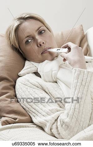 Stock Photography - South Africa, Cape Town, Sick young woman with thermometer in mouth. Fotosearch