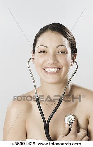 South Africa, Cape Town, Smiling young woman examining self with stethoscope View Large Photo Image Stock Photography - South Africa, Cape Town, Smiling young woman examining self with stethoscope. Fotosearch